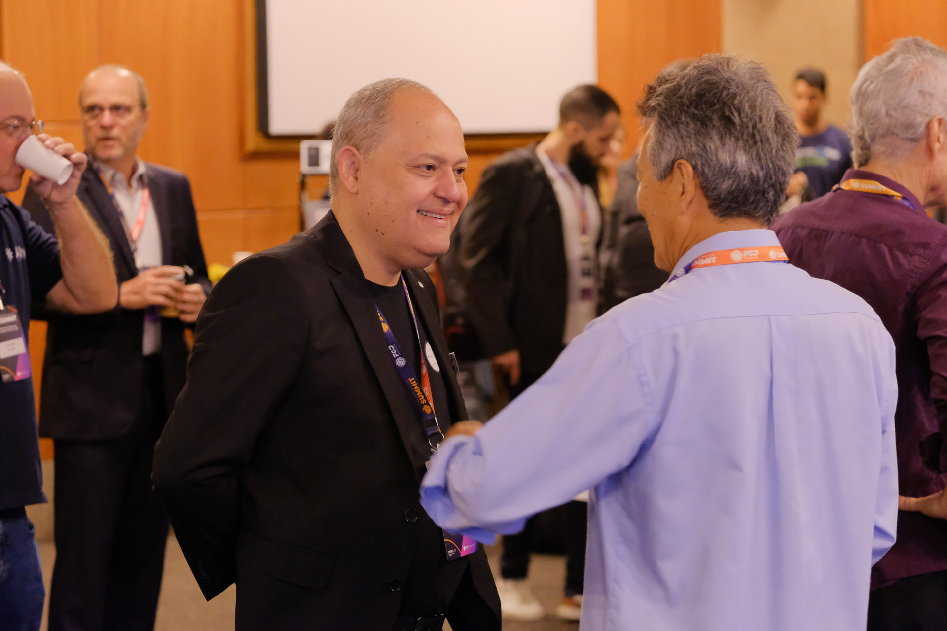 Aperto de mãos entre executivo e fundador em evento de networking